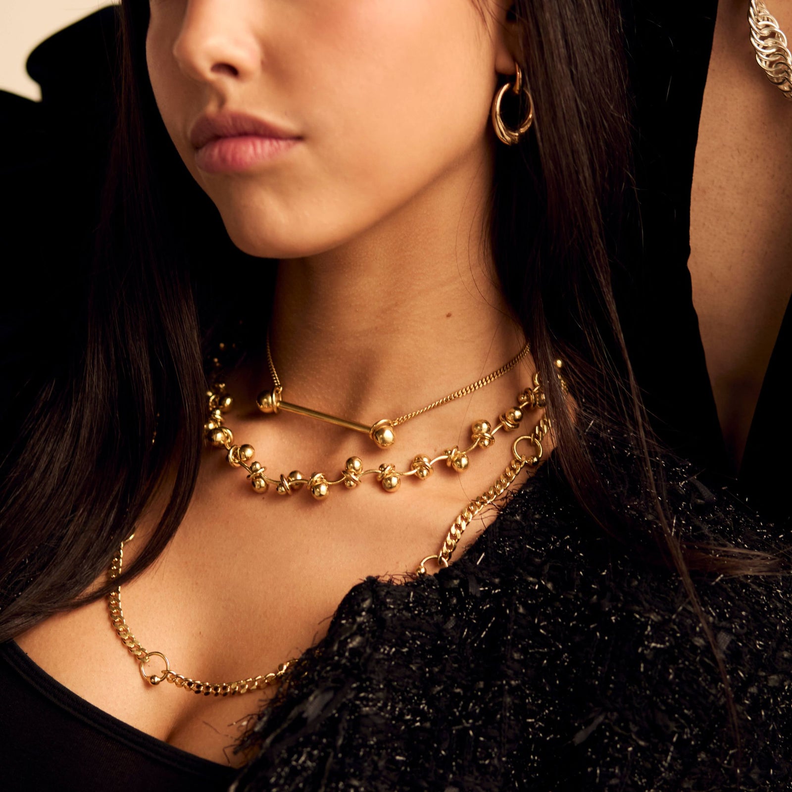 Pierced chain necklace layered with other styles